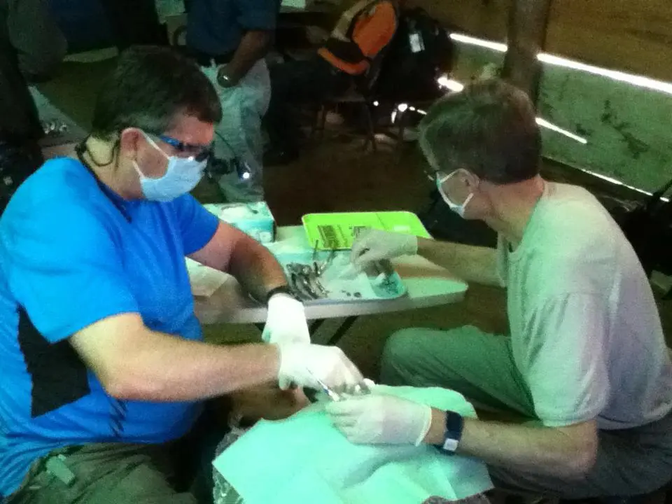 Doctors performing dental work on patient